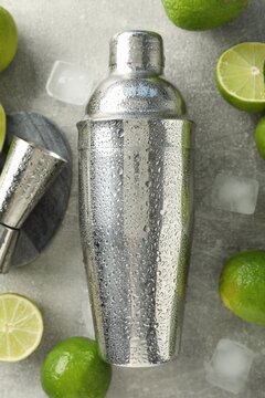 Ingredients for mojito, shaker and jigger on light grey table, flat lay