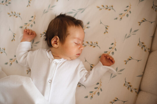 Cute infant baby sleeping in crib close up top view. Childhood.