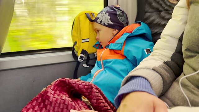 A young boy looks out a bus window while traveling through Karelia. The cozy ride brings a calm and peaceful feeling of comfort.