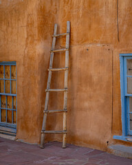 wooden ladder resting against adobe building  © Blue Gorilla Photo