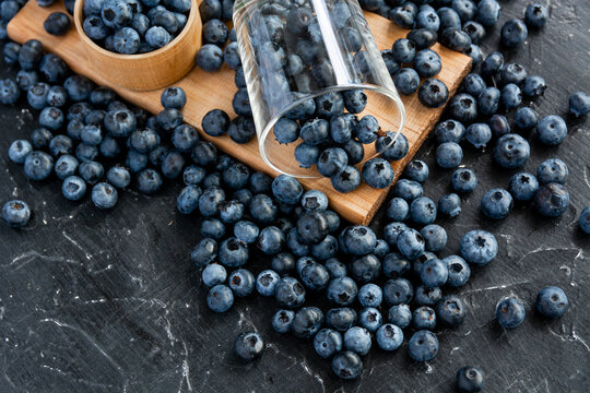 fresh ripe blueberries on a dark textured background. Healthy organic summer berries with green mint leaves.