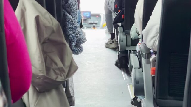 Passengers ride inside a tour bus traveling through Karelia, Russia. The cozy aisle feels calm and relaxing during the smooth journey.