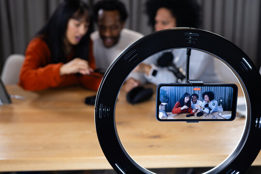 Diverse content creators recording live stream at home with ring light smartphone microphone