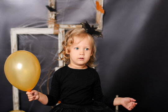 Little Girl Holding Yellow Balloon for Halloween