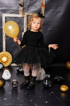 Little Girl in Black Tutu Dress Holding Yellow Balloon for Halloween
