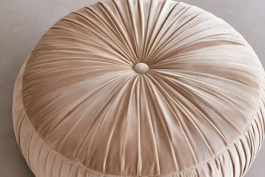 Taupe pleated round footstool with a center tuft