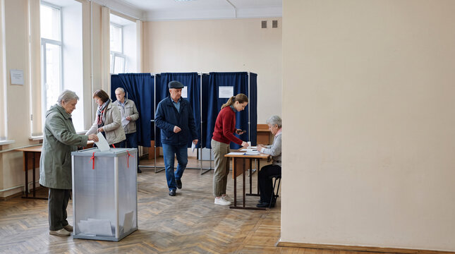 Personnes &acirc;g&eacute;es d&eacute;posant leur bulletin dans un bureau de vote