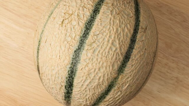 Ripe cantaloupe melon rotating on wooden background