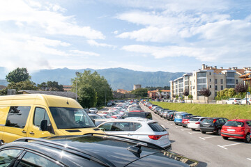 Obraz premium Llanes parking lot filled with cars by mountains