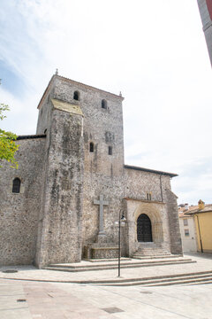 Llanes church building standing with ancient stone cross