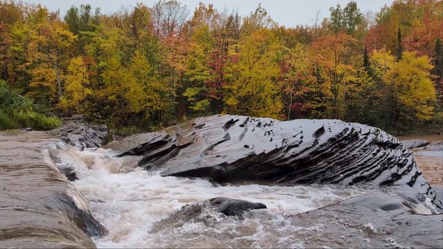 Bonanza Falls cascades over rock ledges in Ontonagon County Michigan in the autumn rain