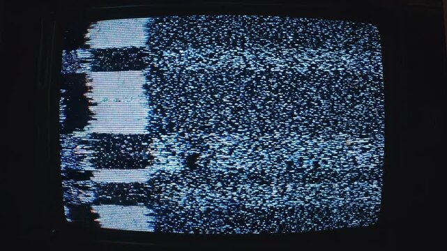 Retro television screen with static glitches during broadcast interruption in a dark room