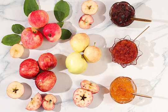 An assortment of preserves, fruit butters and fresh fruit purees arranged on a concrete kitchen counter.Fresh apple butter or jam made from various apple varieties. home canning concept, banner