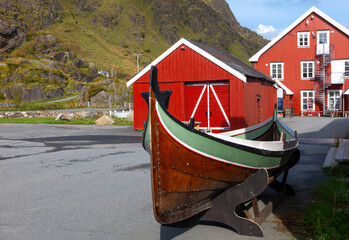 Traditional wooden fishing boat and red houses in Stamsund, Lofoten Islands, Norway © Comofoto