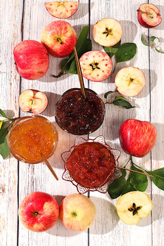 Fresh apple butter or jam made from various apple varieties.An assortment of preserves, fruit butters and fresh fruit purees arranged on wooden kitchen counter. home canning concept, banner