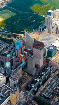 Vertical video. The Hague, Netherlands. Business center of The Hague. Large train station Den Haag Centraal. Cloudy weather. Summer day. Drone footage. Rich colors