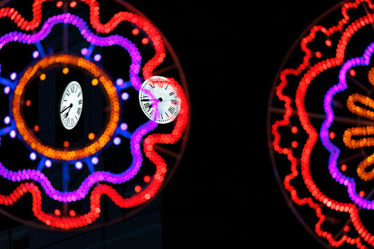 Conceptual vintage clocks floating inside colorful neon light circles at night, Puerta del Sol Madrid style countdown abstract background