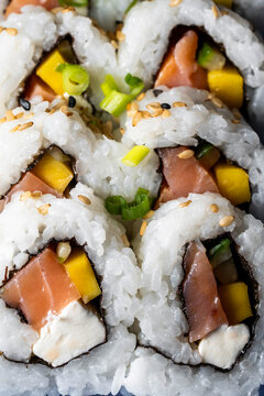 Up close of smoked salmon sushi with vegetables and sesame seeds and scallions   