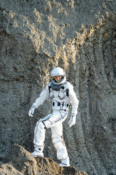 Astronaut explores lunar surface near rocky formations during moon mission