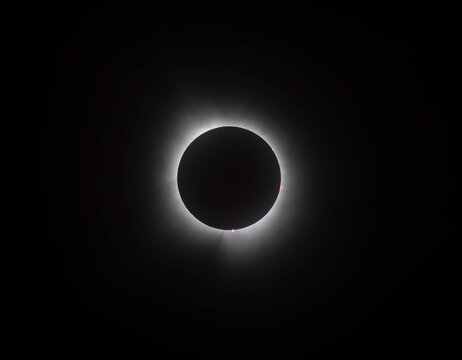 A total solar eclipse glows against the dark night sky.