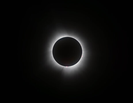 A total solar eclipse glows against the dark night sky.
