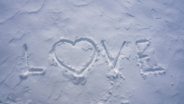 Love symbol in snow. Romantic winter heart pattern. Snow heart on snowy surface in winter. Love winter design for banner. Snowy heart template with snowflakes. Heart shaped in snow. Love winter.