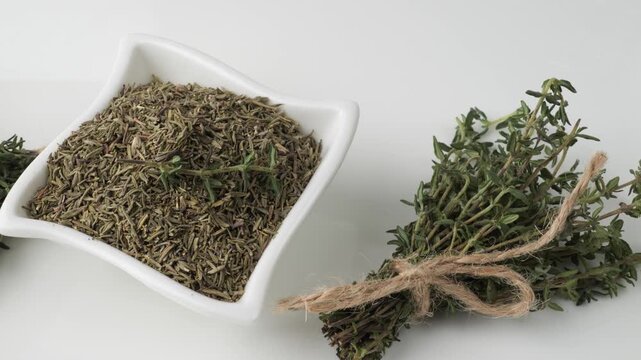 Fresh and dried thyme seasoning on white background