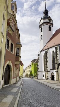 Vertical video shows picturesque cobblestone road amid old European architecture
