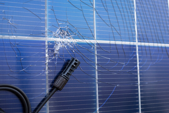 Damaged Solar Panel with Cracked Surface and Electrical Connector
