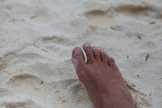 Right barefoot on a white sand beach