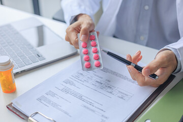 Medical doctor writing prescription form for patient treatment plan in modern office © Supitnan