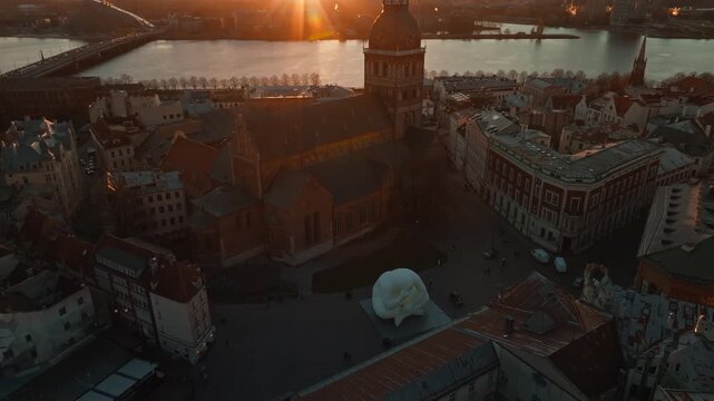 Dome square, cathedral and art object at dusk from drone, Riga. Aerial shot above old town rooftops of Riga, Latvia, with Dome cathedral.