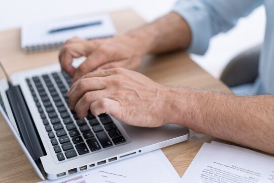 Man hands typing on computer keyboard closeup, businessman using laptop at office