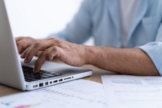 Man hands typing on computer keyboard closeup, businessman using laptop at office
