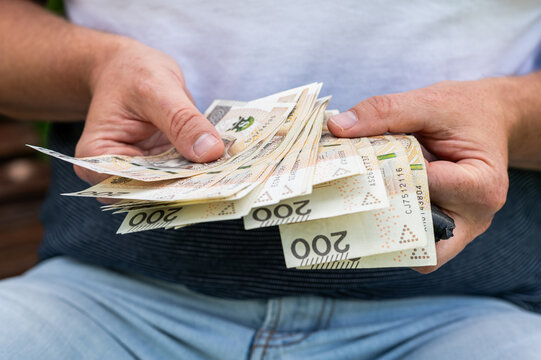 Male Hands Holding and Counting Large Stack of Polish 200 Zloty Bills for Business Finance
