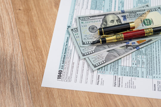 Close up of American Dollar Bills on US Tax Return Form 1040 Document for Accounting Concept