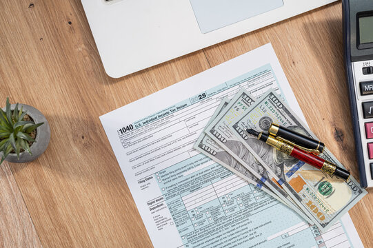 Top View Workspace with Laptop and US Tax Form 1040 for Online Accounting and Audit Concept