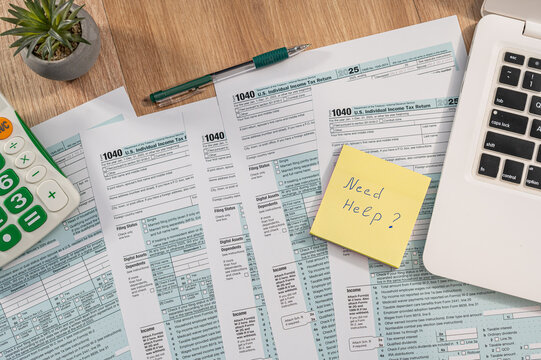 Close up of US Tax Form 1040 with Need Help Note and Calculator for Financial Advisory Concept