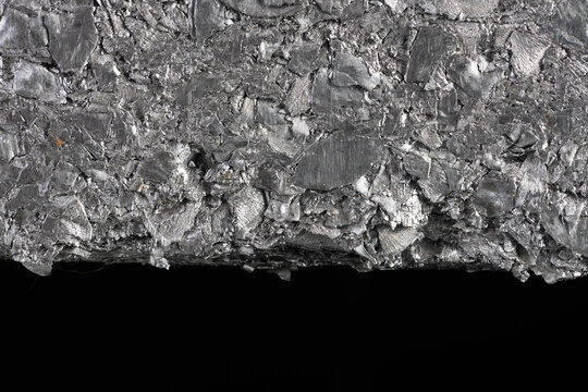 Closeup compressed block of aluminum scrap formed from processed non ferrous metal waste. Secondary raw material for metallurgical and metal processing industries