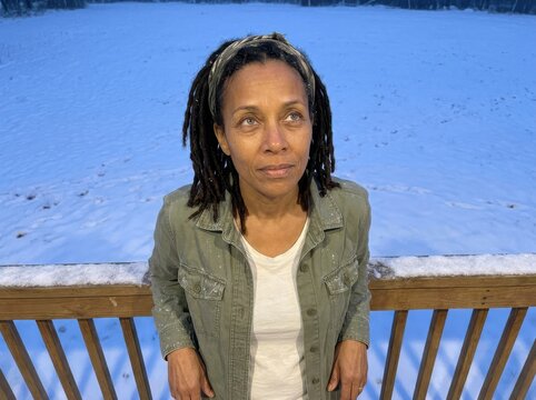 Contemplative Woman Standing on Snowy Deck in Winter
