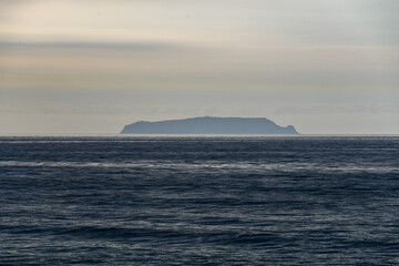 Île Sisarga Grande et son phare, silhouette se détachant dans la brume au large des côtes de Galice, Espagne © William Vallée