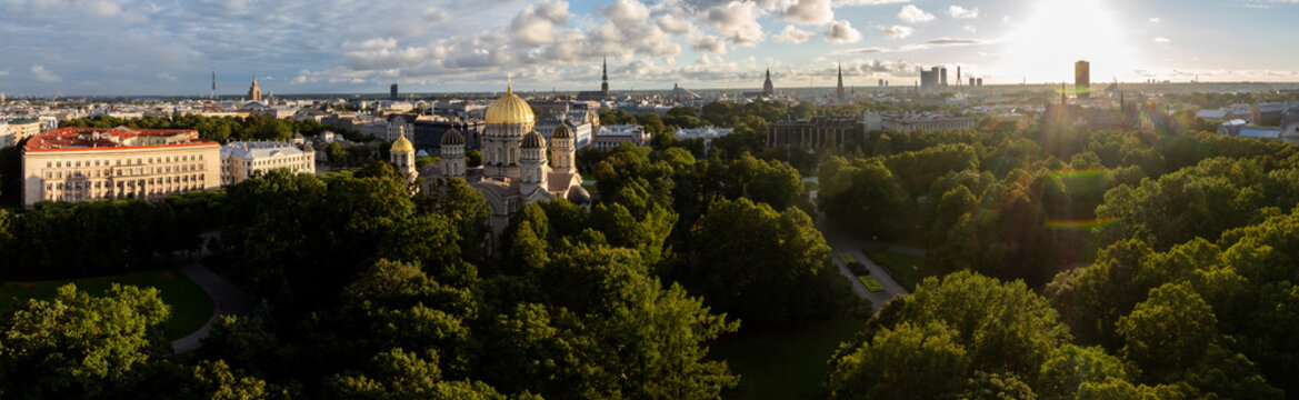 Esplanade park and orthodox cathedral, ultra wide drone panorama, Riga, Latvia. Drone very wide panoramic view over green park lawns and tree crowns with the golden domed church, historic buildings.