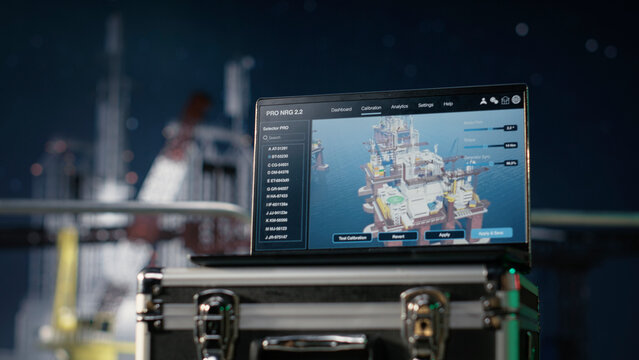 Laptop on an offshore platform monitors petrol production logistics during a maritime supply bottleneck, while notebook software evaluates oil drilling performance during a fuel crisis under aurora.