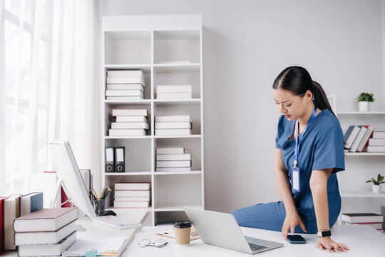 Exhausted Healthcare Worker: A nurse in scrubs sits dejectedly on a desk in an office, overwhelmed by the demands of her profession. The scene conveys the emotional toll of healthcare work