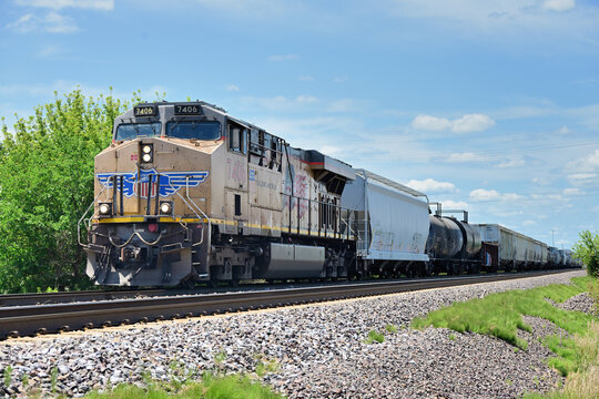 With its merchandise freight train spread out behind it, a lone locomotive leads an eastbound Union Pacific manifest freight train slowly toward a diamond corssing in norch central Illinois.