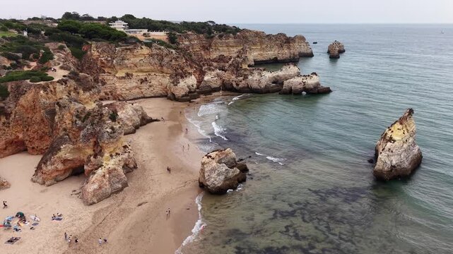 People sunbathing at three brothers beach in alvor, portugal