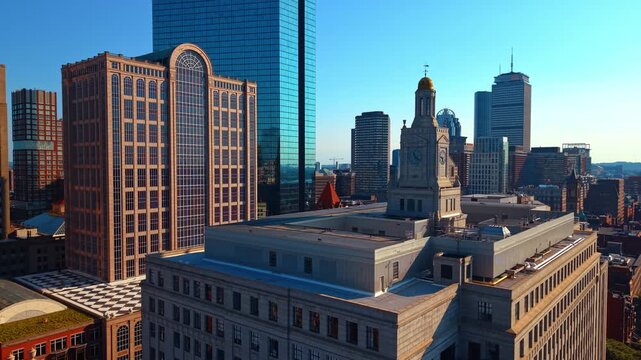 Clock tower at 501 Boylston Street among Back Bay buildings in Boston. A gold dome tops a stone tower beside blue glass facades under a clear sky.