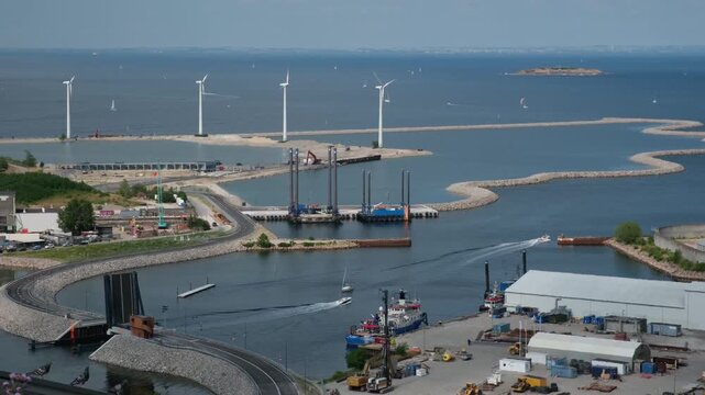 Aerial view of Copenhagen harbor featuring wind turbines, boats, and industrial areas