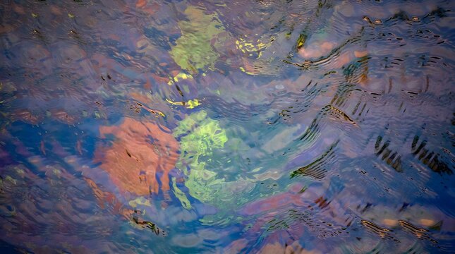 A mesmerizing, dramatic macro texture displaying vibrant rainbow iridescence and psychedelic flowing swirls of colorful oil sheen on water