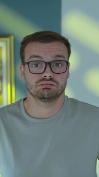 Man blows air through his lips with an uncertain and disappointed expression, concept of frustration, doubt, disappointment and lack of confidence.